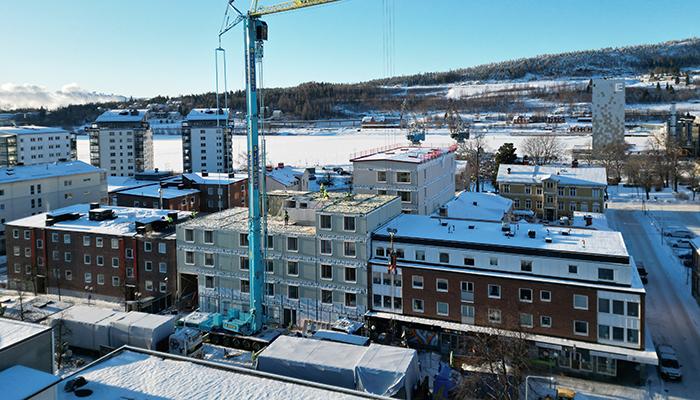 Stadskvarter mitt byggkran i snölandskap